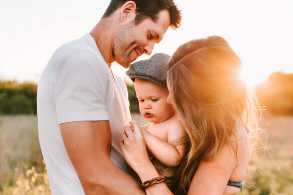 Young mother and father holding baby - Life Insurance
